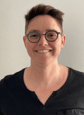 A woman with short brown hair and glasses